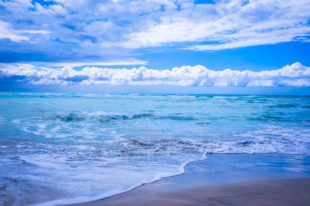 Captivating beach scene with waves and a vibrant blue sky, perfect for coastal themes.