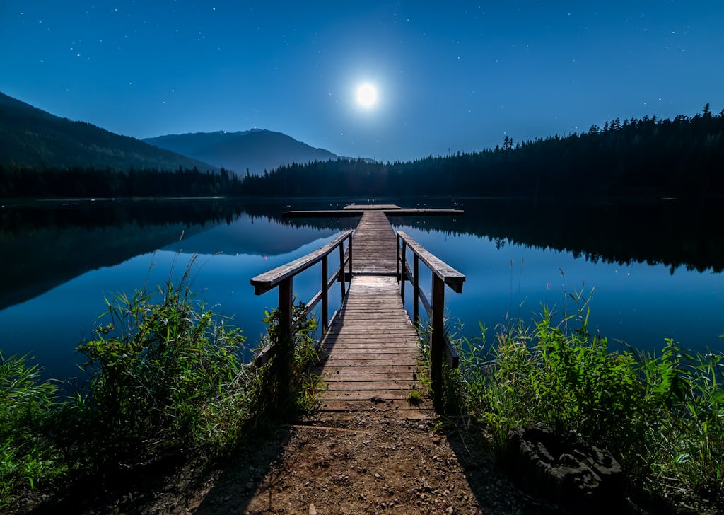 Discover tranquility at a moonlit dock in Whistler, BC, under a starry sky.
